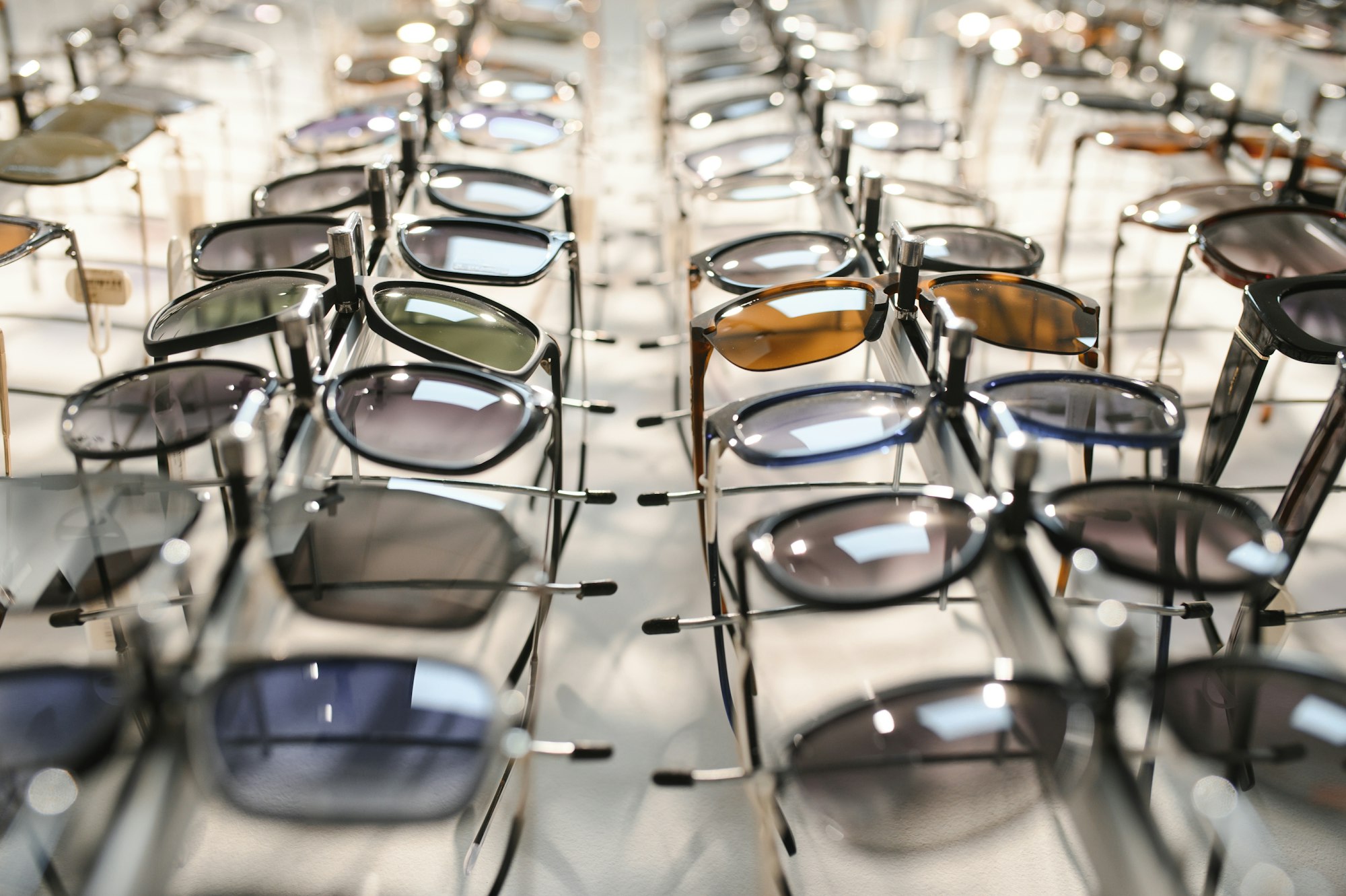 Sunglasses on display shelves in glasses store.