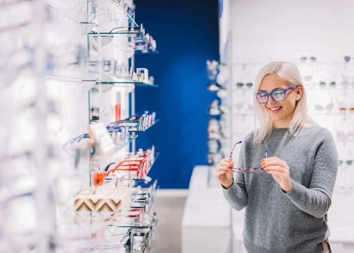 Woman looking at glasses at optic store.
